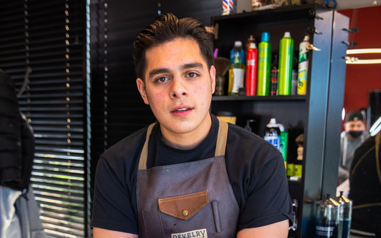 Barber with a brown apron and black shirt