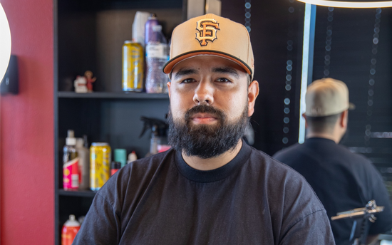 Barber with a black shirt and brown hat