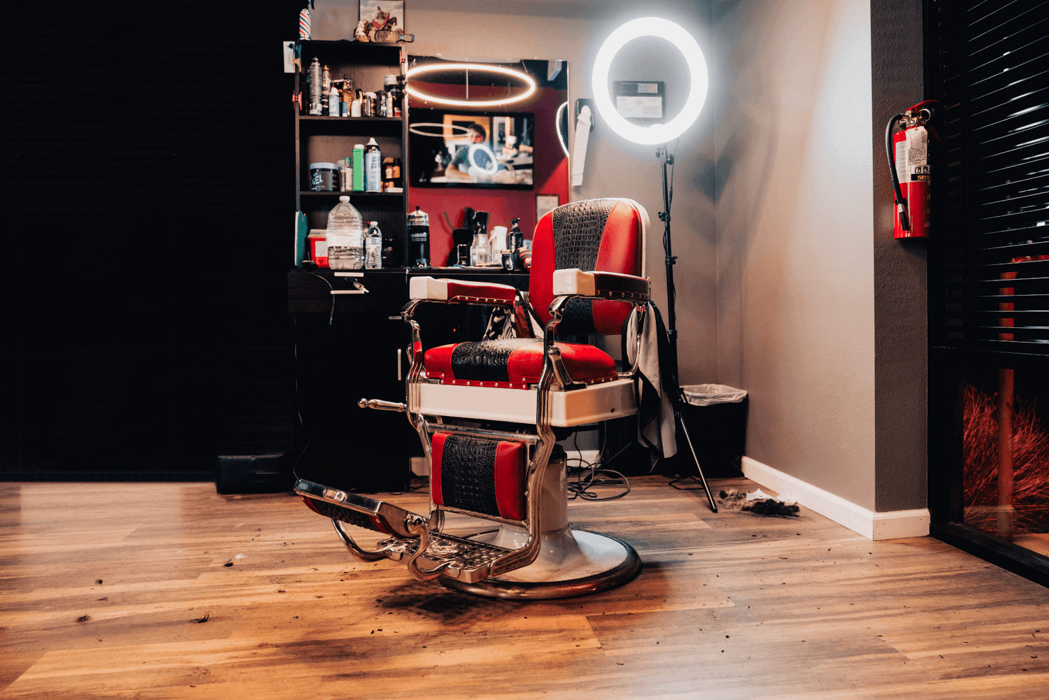 Red and black barber chair with a light behind it.